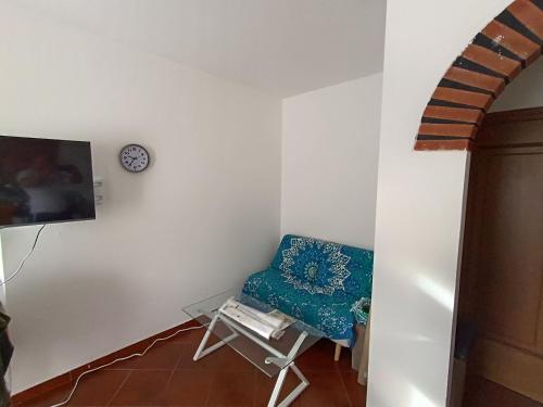 een kamer met een stoel en een klok aan de muur bij A mezz'ora da Genova e dal Mare in Tasso