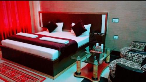 um quarto com 2 camas, uma mesa e uma cadeira em Vamoose Sachin International em Rudraprayāg