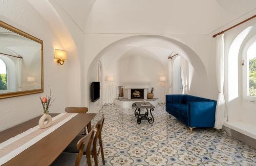 een woonkamer met een blauwe bank en een open haard bij Villa Pineta - Holiday House in Anacapri