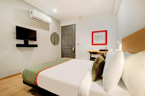 een slaapkamer met een wit bed en een bureau bij Townhouse 219 in Gurgaon