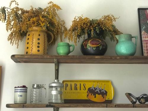 a shelf with vases and a box on it at La Maison Ancienne Eymet in Eymet