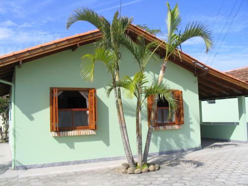 two palm trees in front of a house at Pousada Barratur in Florianópolis