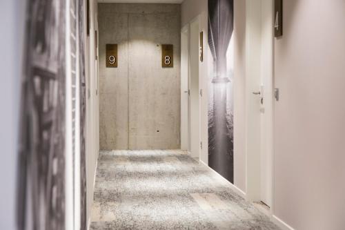 an empty hallway with numbers on the walls at Toploft The Aparthotel in Crailsheim