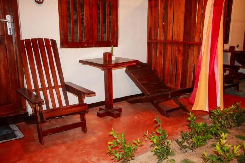 a room with two wooden chairs and a table at Surfers Park Arugambay in Arugam Bay