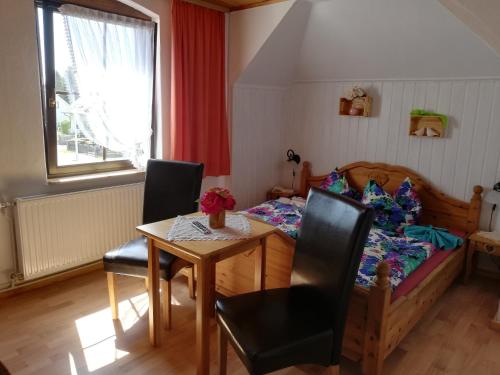 1 dormitorio con 1 cama, mesa y sillas en Pension Haus zum See en Markische Heide