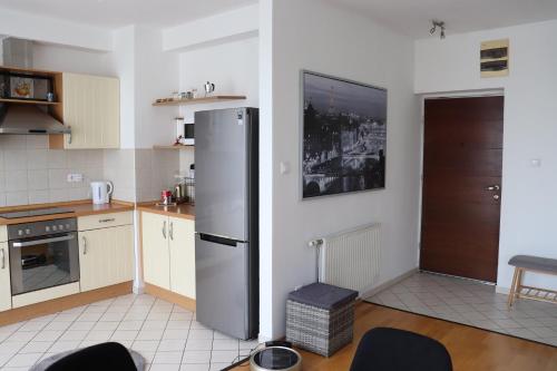 a kitchen with a stainless steel refrigerator next to a door at Budapest Penthouse & View in Budapest