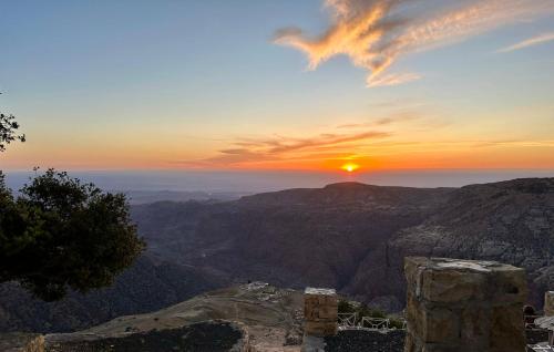 a view of the sunset from the top of a mountain at Jabal Dana Hotel - the highest hotel in Jordan in Dana