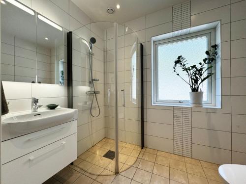 łazienka z prysznicem, umywalką i oknem w obiekcie Lovely villa with a view of the Byfjorden and Uddevalla w mieście Uddevalla