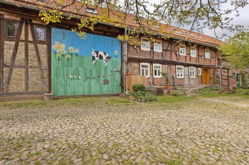 a building with a blue door with a cow painted on it at Ferienwohnung Gute Stube in Veckenstedt
