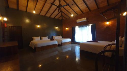 a room with two beds and a window in it at Ceylon Resort in Wilpattu