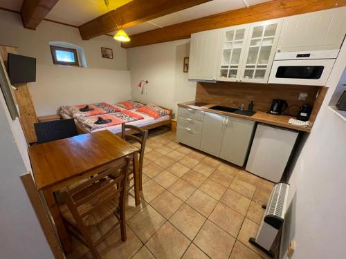 a small kitchen with a table and a bed at Jihočeský Statek in Dynín