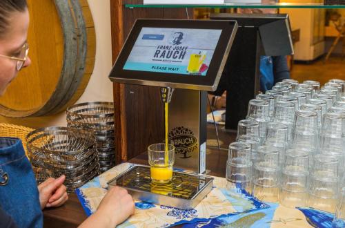 a woman standing next to a table with a drink mixer at Hotel & Restaurant Hanse Kogge in Ostseebad Koserow