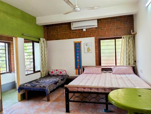 1 Schlafzimmer mit 2 Betten und einem Tisch in der Unterkunft Yangzom Homez in Shiliguri