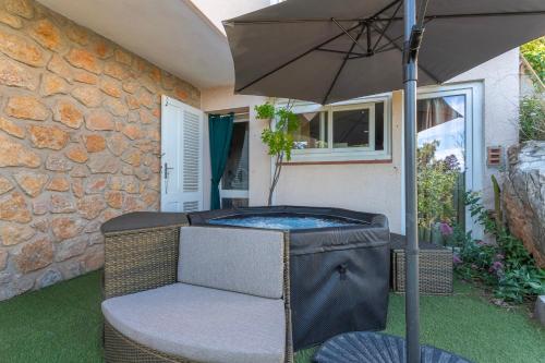 une terrasse avec un parasol et un bain à remous dans l'établissement 3 bedroom artist's house with AC, spectacular sea view - Dodo et Tartine, à Toulon