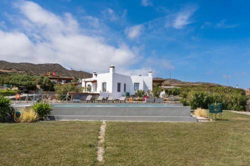 a white house with a lawn in front of it at Luna Rossa Milos - Cocoon in Provatas