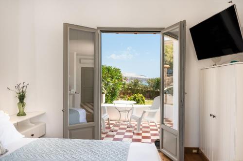 a bedroom with a bed and a view of a patio at Luna Rossa Milos - Cocoon in Provatas