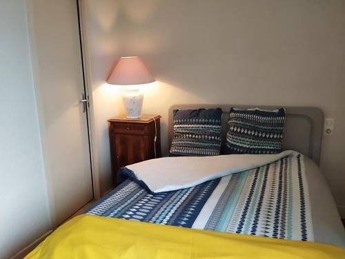 a bedroom with a bed with a lamp on a night stand at Gite Le Lucimond in Saint-André