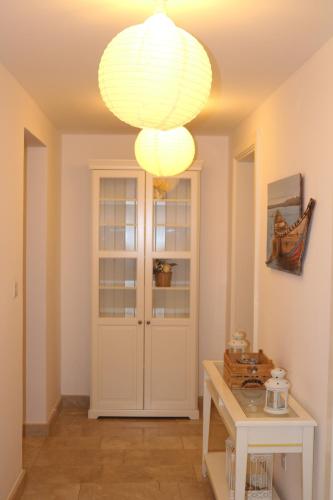 a room with a white door and a chandelier at Jabal Sifah Tha Marina View Apartment in Muscat