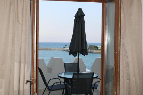 a patio with a table and an umbrella at Jabal Sifah Tha Marina View Apartment in Muscat