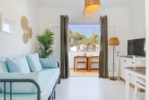 a living room with a couch and a view of the ocean at Casa Lo-LA - Apartamento sereno y lujoso con balcón in Cala'n Bosch
