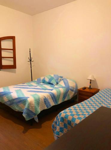 a bedroom with two beds and a table with a lamp at Copacabana’s House Microcentro in Salta