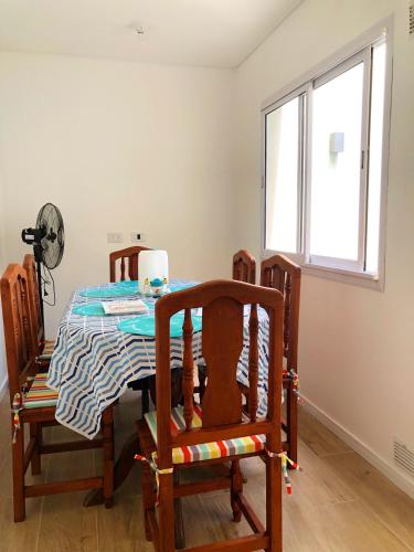 a dining room table with chairs and a window at Copacabana’s House Microcentro in Salta