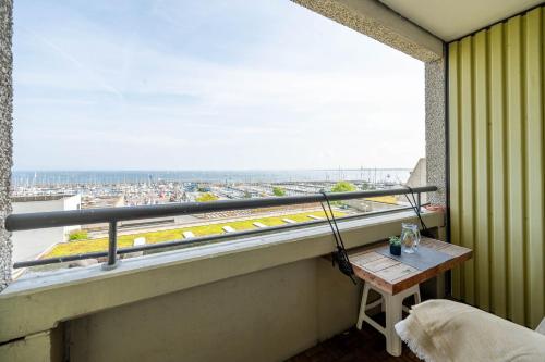 a balcony with a table and a view of a city at Hafenperle in Schilksee