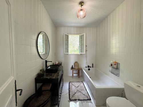 Un baño blanco con bañera y lavabo. en VILLA A MUREDDA, piscine chauffée et vue mer, en Olmeto