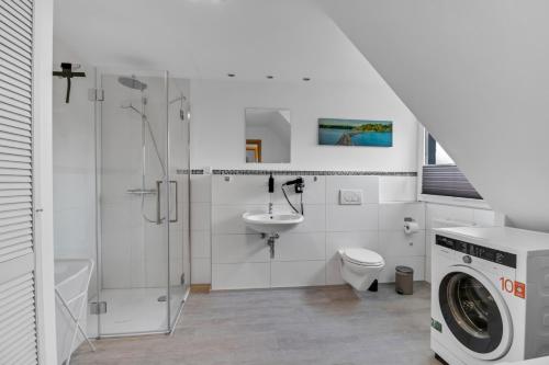 a bathroom with a toilet sink and a washing machine at Nützlich und zentrale Kurzzeitwohnung - Unna DG in Unna