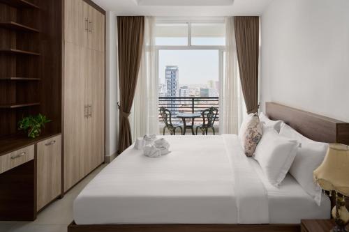 a bedroom with a large white bed and a balcony at Queen Mansion in Phnom Penh