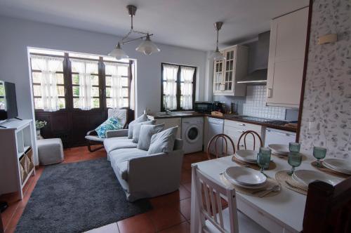 a kitchen and living room with a couch and a table at La Casa de Maria in Santillana del Mar
