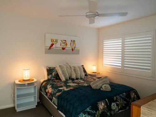 a bedroom with a bed with two night stands and two lamps at Nelson's Oasis by the beach Apartment in Vincentia