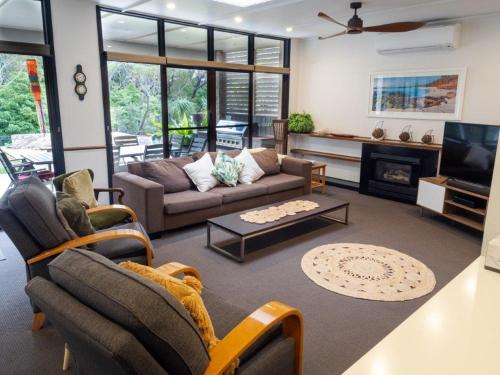 a living room with a couch and a fireplace at Nelson's Oasis by the beach Apartment in Vincentia