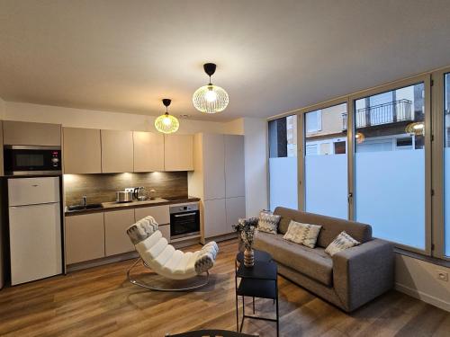 un salon avec un canapé et une cuisine dans l'établissement Appartements 4, 5 et 10 personnes rénovés en centre-ville, à Mont-Dore