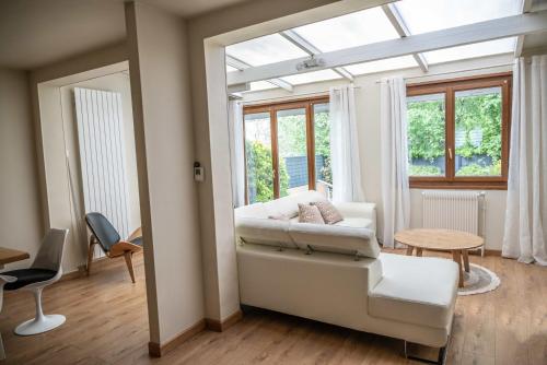 ein Wohnzimmer mit einem weißen Sofa und einem Fenster in der Unterkunft Belle maison lumineuse et paisible in Reims