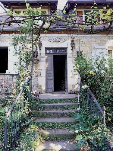 een stenen huis met een trap naar een deur bij Ferme de la Dorvallière in Cavagnac