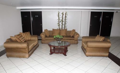 a living room with couches and a coffee table at Hotel Florencia Poza Rica in Poza Rica de Hidalgo