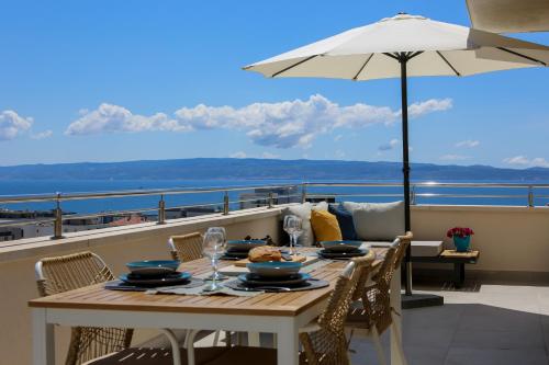 a table on a balcony with an umbrella at Kiki's Sea View Studio's in Split