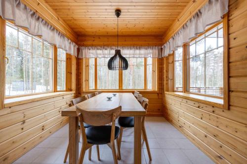 a dining room with wooden walls and a wooden table and chairs at Lomamökki Himos Taivaanranta in Jämsä