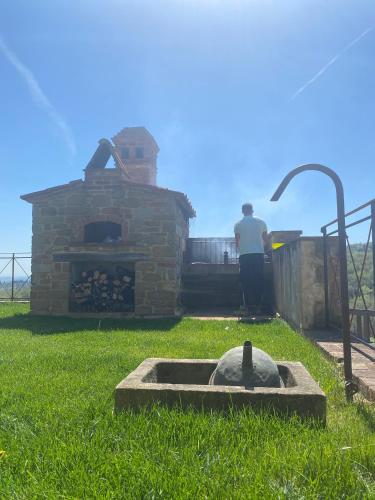 a man standing in front of a brick oven at Podere Cavalbianco in Ciggiano
