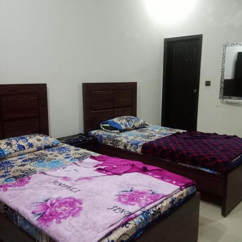 卡拉奇的住宿－HostHub Guest House Gulshan iqbal，一间设有两张床和一台电视的房间