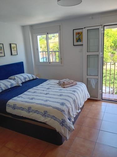 1 dormitorio con 1 cama con edredón azul y blanco en Casita Tolox, en Tolox