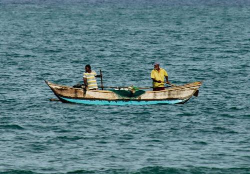 two people in a boat in the water at Surfers Park Arugambay in Arugam Bay