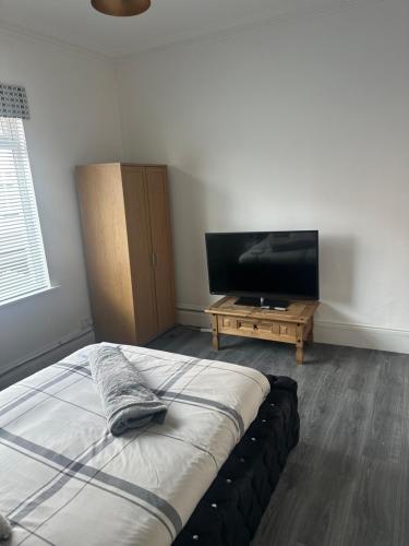 a bedroom with a bed and a flat screen tv at Sheriff suites in Hartlepool