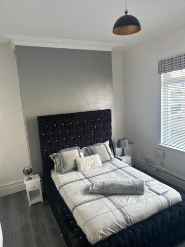 a bed with a black headboard in a bedroom at Sheriff suites in Hartlepool