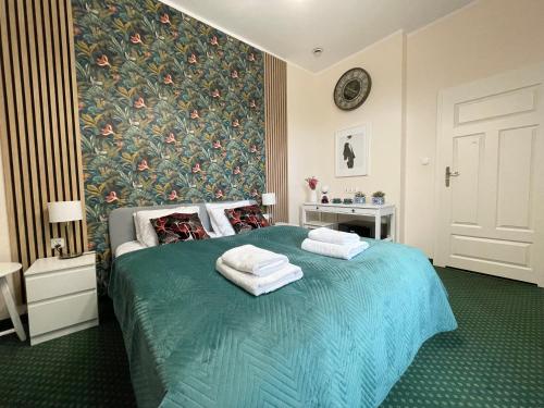 een slaapkamer met een blauw bed en handdoeken bij Gertrudy 10 Residence in Krakau