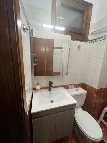 een badkamer met een wastafel, een toilet en een spiegel bij AFISSOS-DREAM 3STUDIOS in Afissos