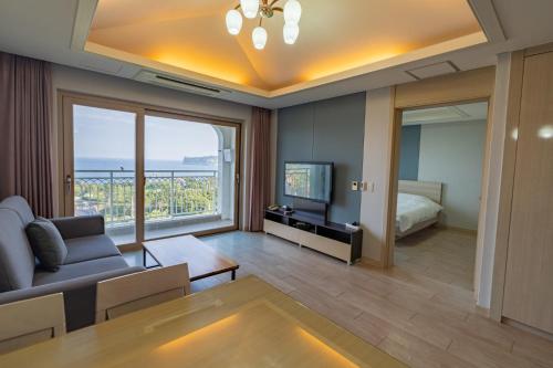una sala de estar con un sofá y un televisor en Seaore Resort, en Seogwipo