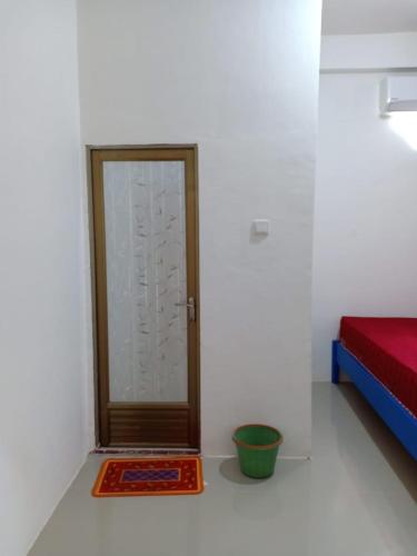 een kamer met een deur in de hoek van een kamer bij WISMA TIGA PUTRA BELAWA 2 in Topoyo