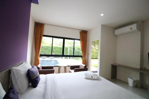 1 dormitorio con cama y ventana grande en S4 Nai Yang Beach - SHA EXTRA PLUS en Nai Yang Beach